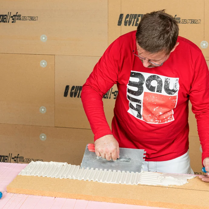 Baumit Handwerker trägt Klebemörtel auf die Holzfaserdämmplatte für die Laibung am Fenster auf. Laibung am Fenster dämmen. Baumit Anleitung zum Selbermachen.