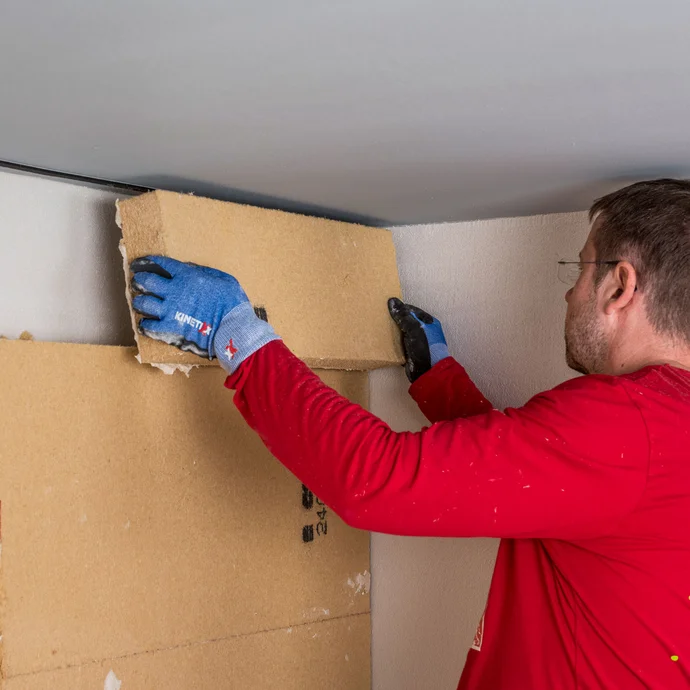 Heimwerker klebt die letzte Holzfaserd&auml;mmplatte als Innend&auml;mmung direkt unter die Decke. Anleitung Baumit Selbermachen.