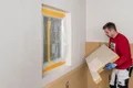 De Thermoroom houtvezelisolatieplaat wordt op de muur gelijmd.