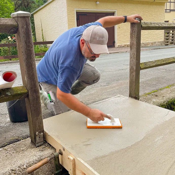 Betonoberfläche wird mit Reibebrett aufgeraut, geglättet und gefilzt.