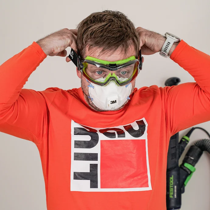 Der Heimwerker sch&uuml;tz sich beim Schleifen mit einer Atemschutzmaske und geschlossenen Schutzbrille.