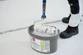 Detailfoto: kant-en-klare rolvuller in een emmer en roller voor aanbrengen.