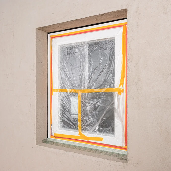 Abgeklebtes Fenster mit Folie und Klebeband zum Schutz vor Schmutz, Kratzer oder Beschädigungen während der Montage der Innendämmung. Baumit Selbermachen DIY Anleitung.