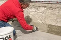 De tweede laag Baumit Dichtschlämme flexibel wordt aangebracht met een verfkwast.