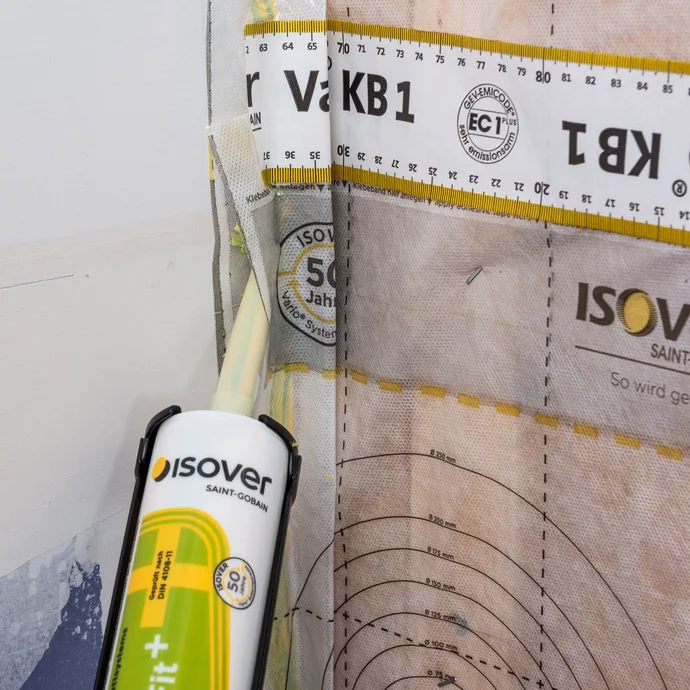 Die überlappte Bahnen der Dampfbremse werden besonders sorgfältig im Stoßbereich zur Wand mit dem Dichtstoff ISOVER Vario DoubelFit+ abgedichtet und angeklebt.