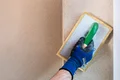 Baumit kalkpleister RK 39 buiten wordt op de muur gevilt.