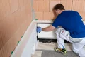De plintisolatieplaat wordt bevestigd aan de hoek van het metselwerk.