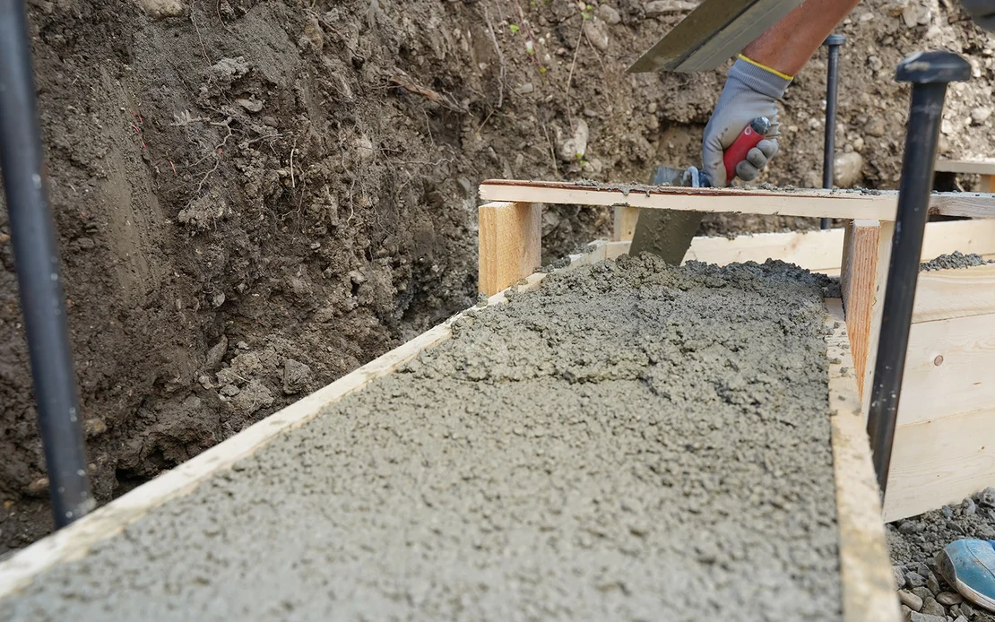 F&uuml;r das Streifenfundament ist die Oberfl&auml;che des frischen Betons in der Schalung eben abgezogen.