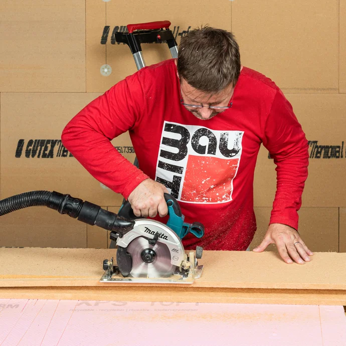 Mit einer Handkreissäge wird die Holzfaserdämmplatte zugeschnitten für den Deckenanschluss. Dabei wird die Nut abgesägt. Baumit Anleitung zum Selbermachen.