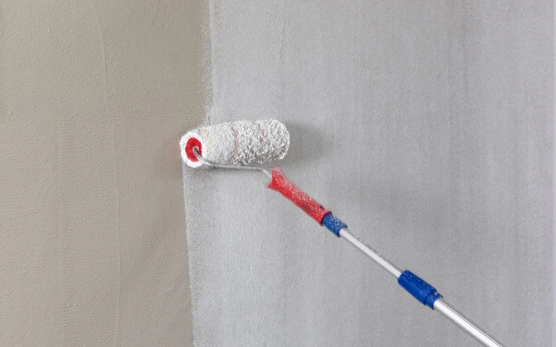 Wand wird mit gro&szlig;er Farbrolle mit wei&szlig;er Baumit Universalgrundierung grundiert.