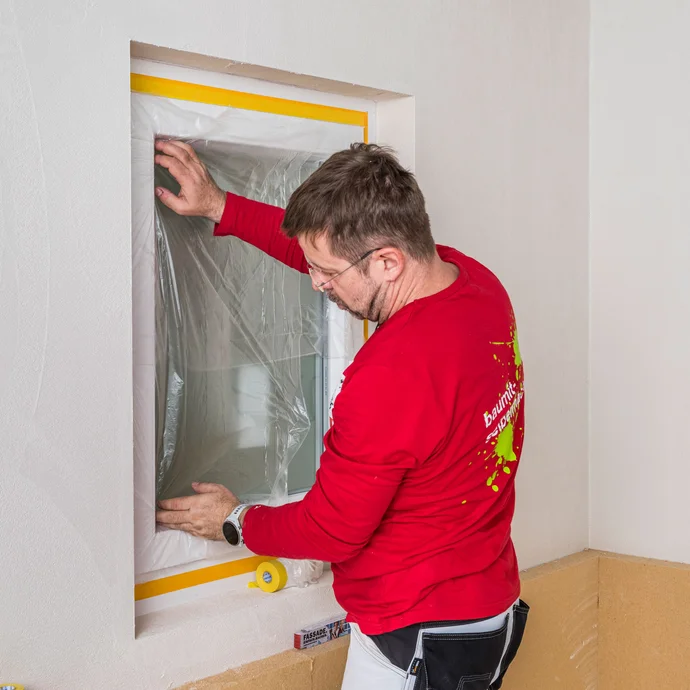 Das Fenster wird mit einer Schutzfolie abgedeckt, damit es nicht verschmutzt wird.