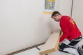 De Thermoroom houtvezelisolatieplaat wordt op de muur gelijmd.