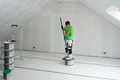 De doe-het-zelver doopt de roller in de kant-en-klare rollerplamuur.