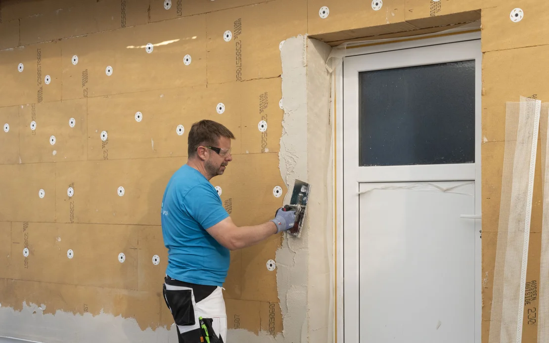 Der Gewebe-Eckwinkel wird auf die Holzfaserd&auml;mmung geklebt und mit Baumit Multicontact eingebettet.