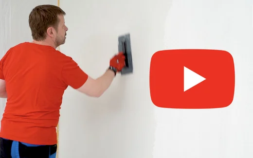 Heimwerker beim Verputzen einer Wand mit Gl&auml;ttkelle, Videoanleitung verf&uuml;gbar.